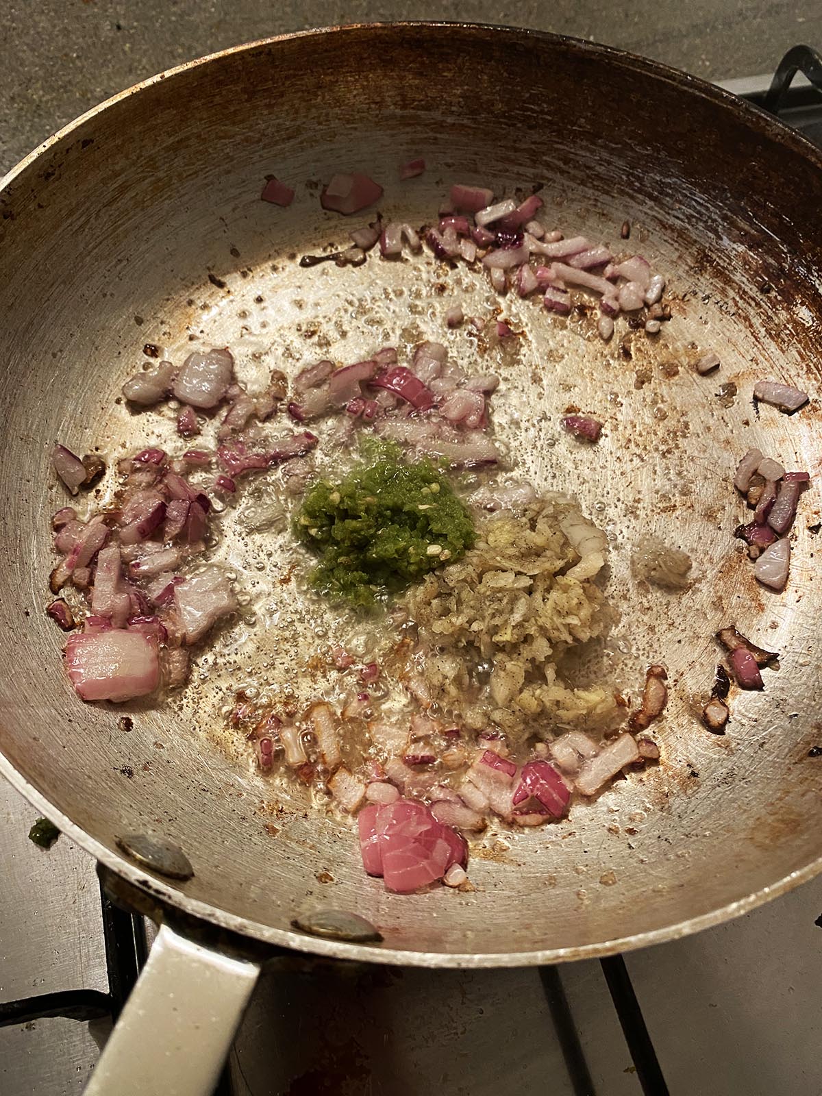 Adding garlic and ginger paste and chilli paste to pan