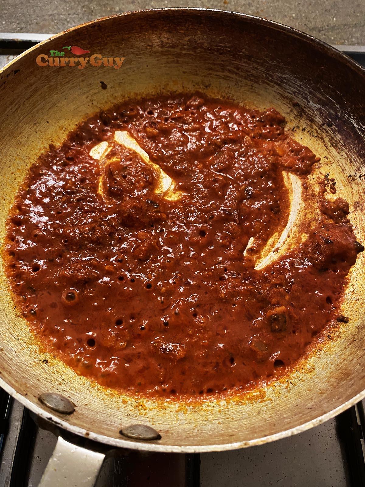 Adding tomato puree to pan