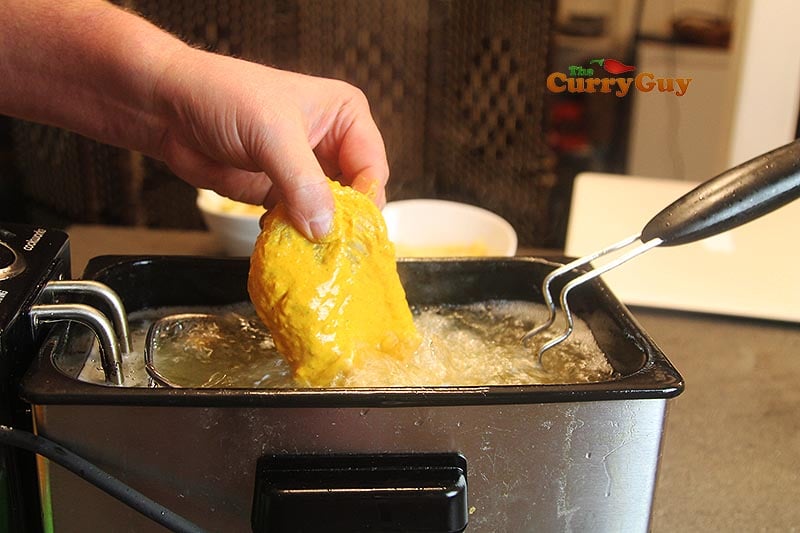 Adding fish to the hot oil.