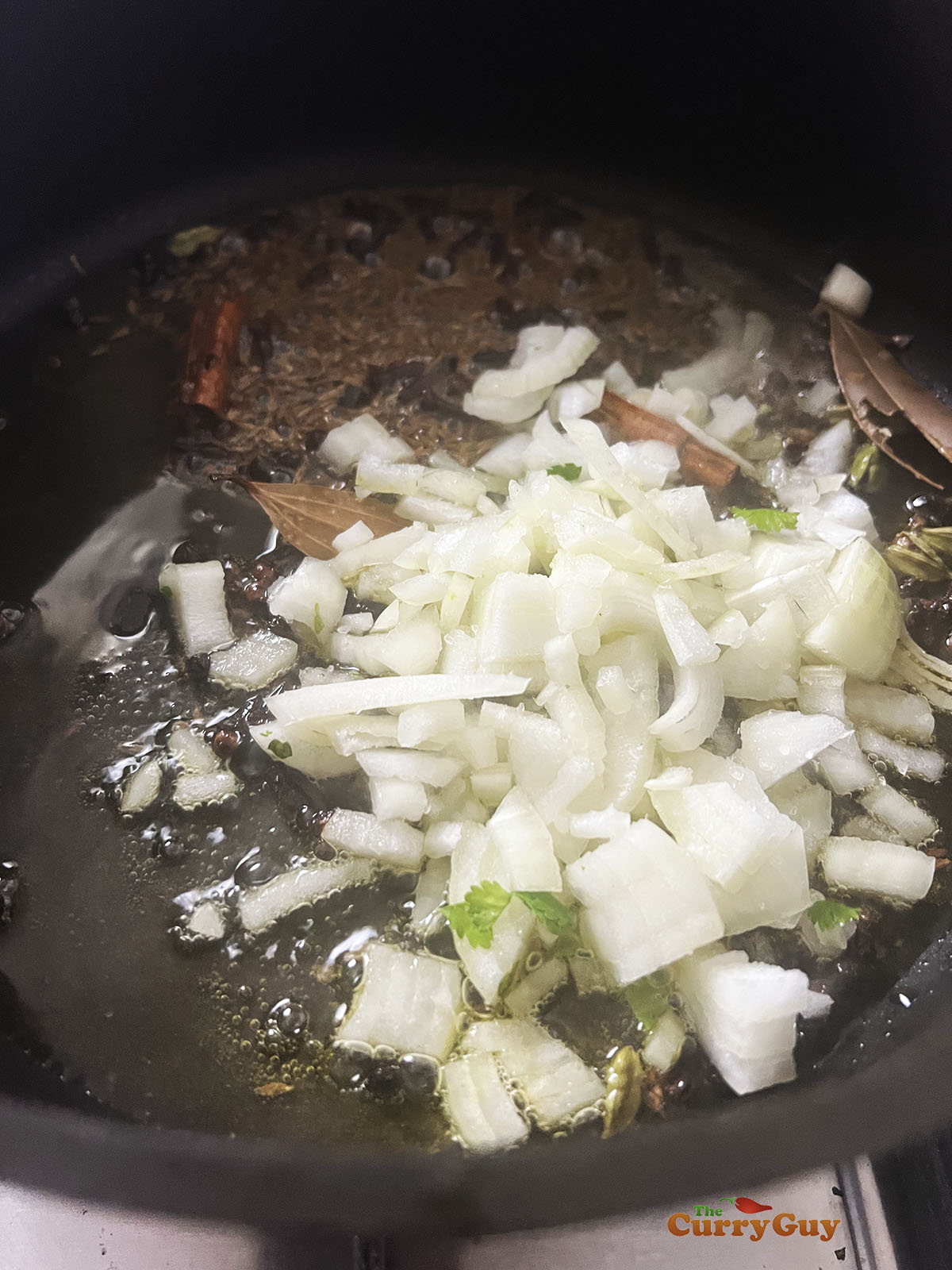 Frying the onions in the spiced ghee mixture.