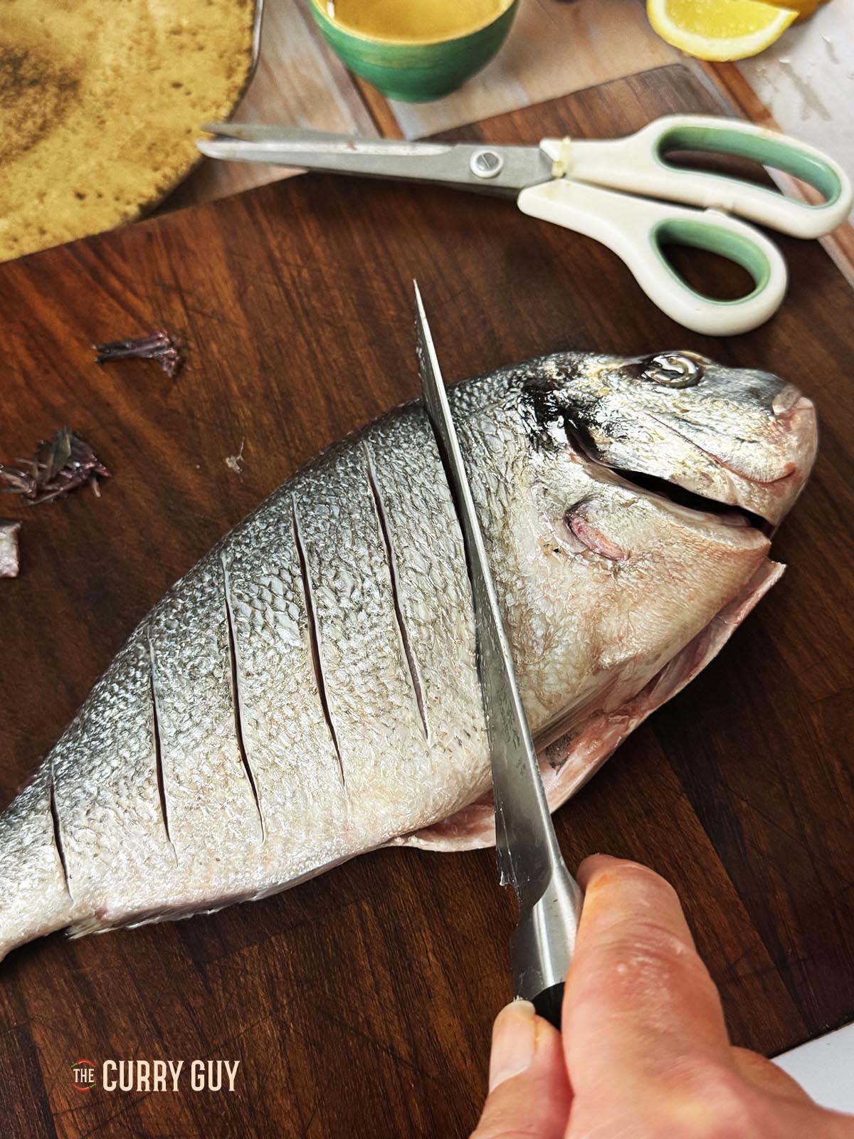 Scoring the fish so that the marinade penetrates it better.