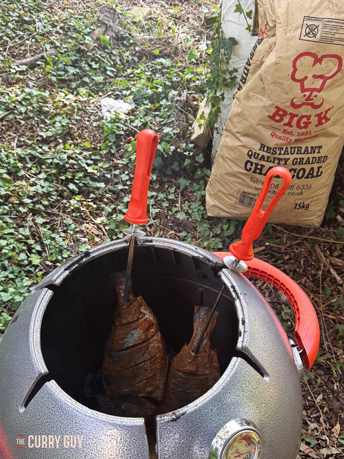 Placing the fish in the tandoor oven.