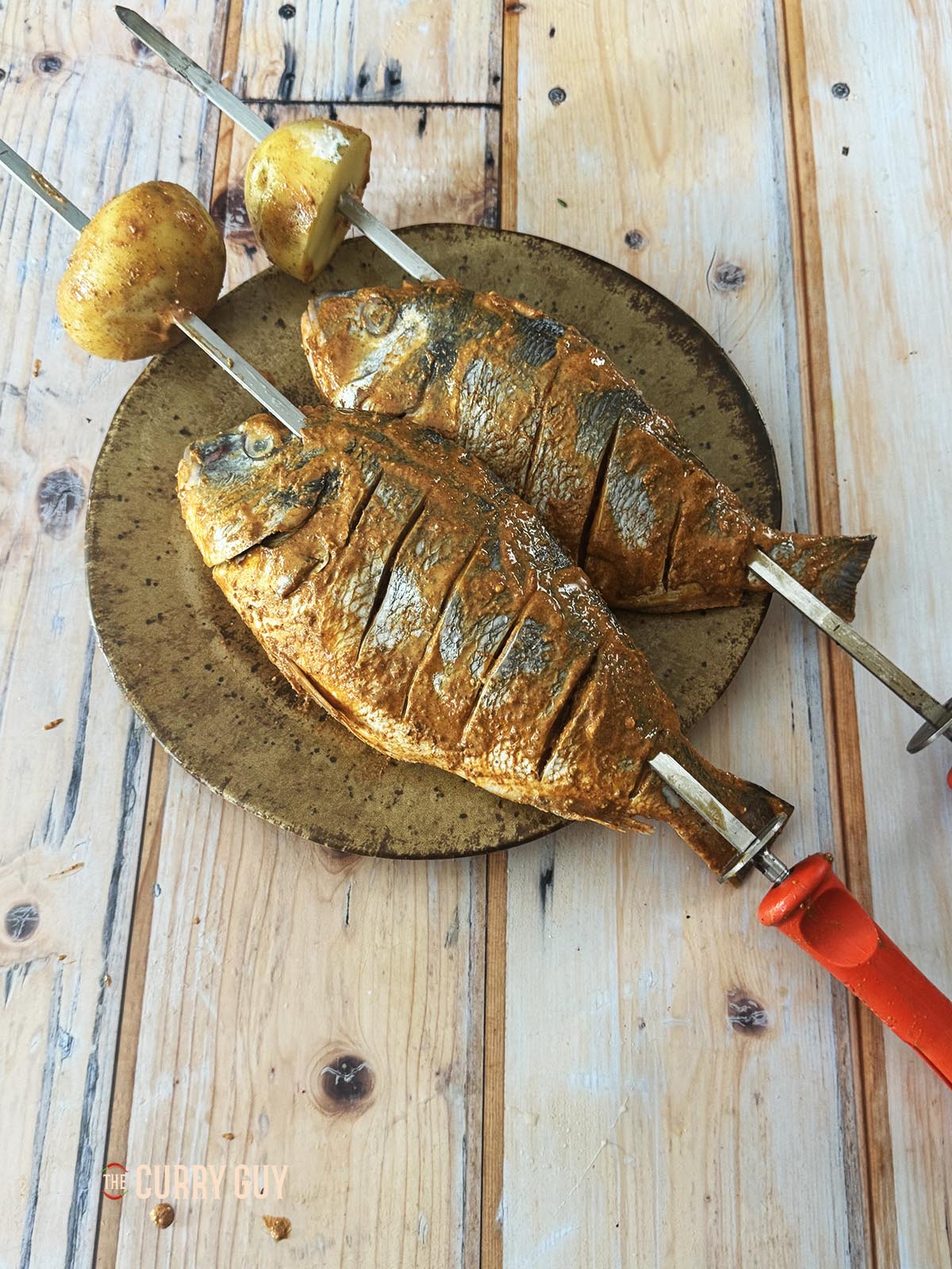 Potatoes at the end of the fish skewers.