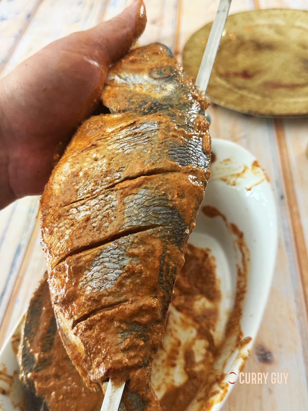 Skewering one of the fish.