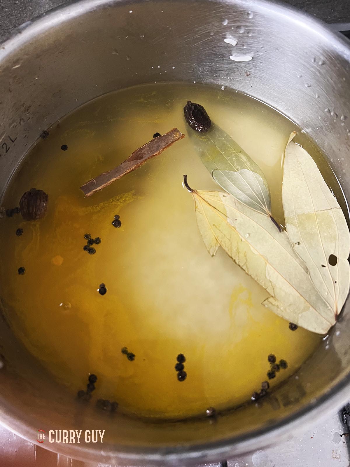 The rice and spices in a saucepan covered with water. 