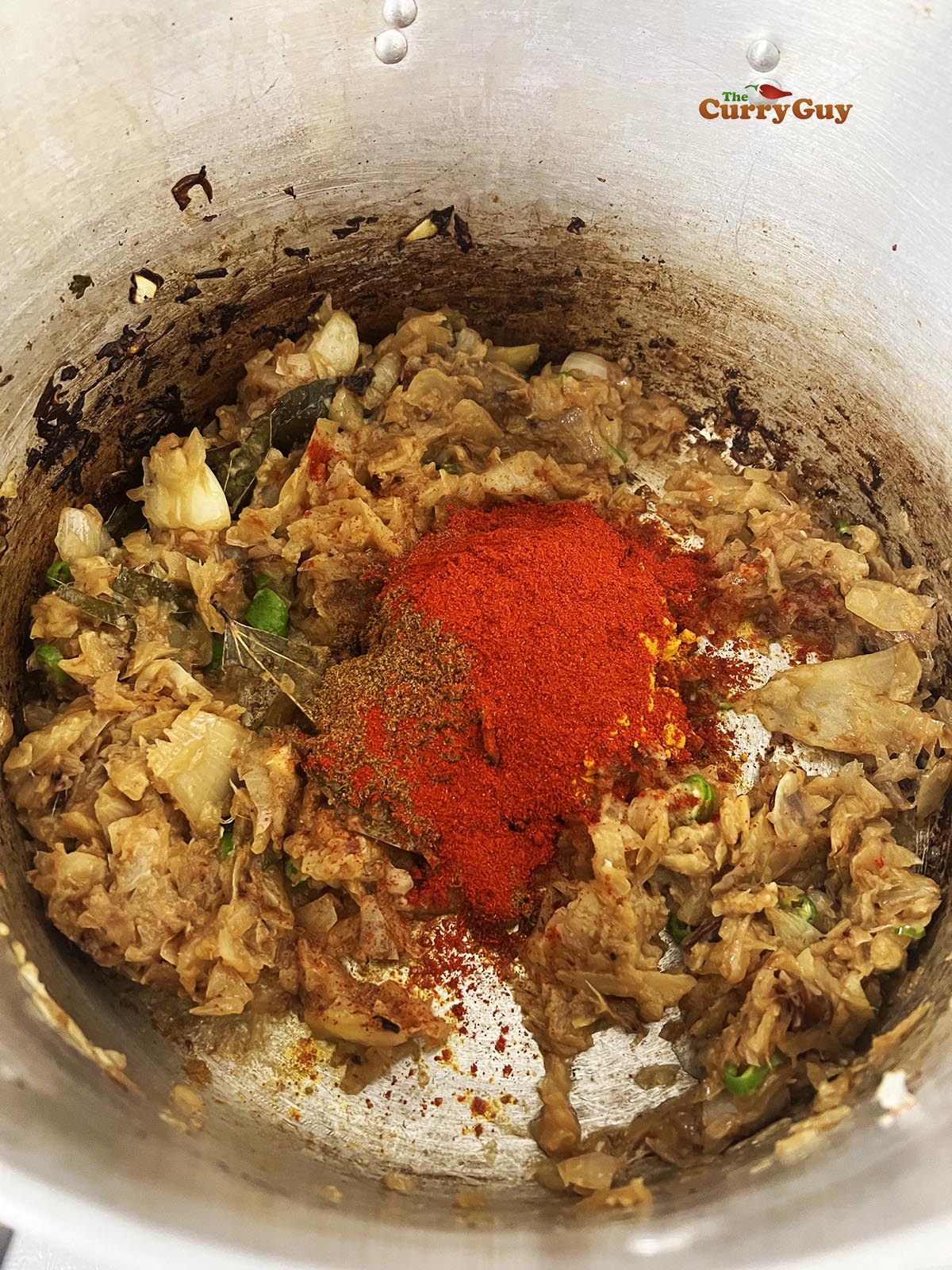 Adding the ground spices to the onion mixture.