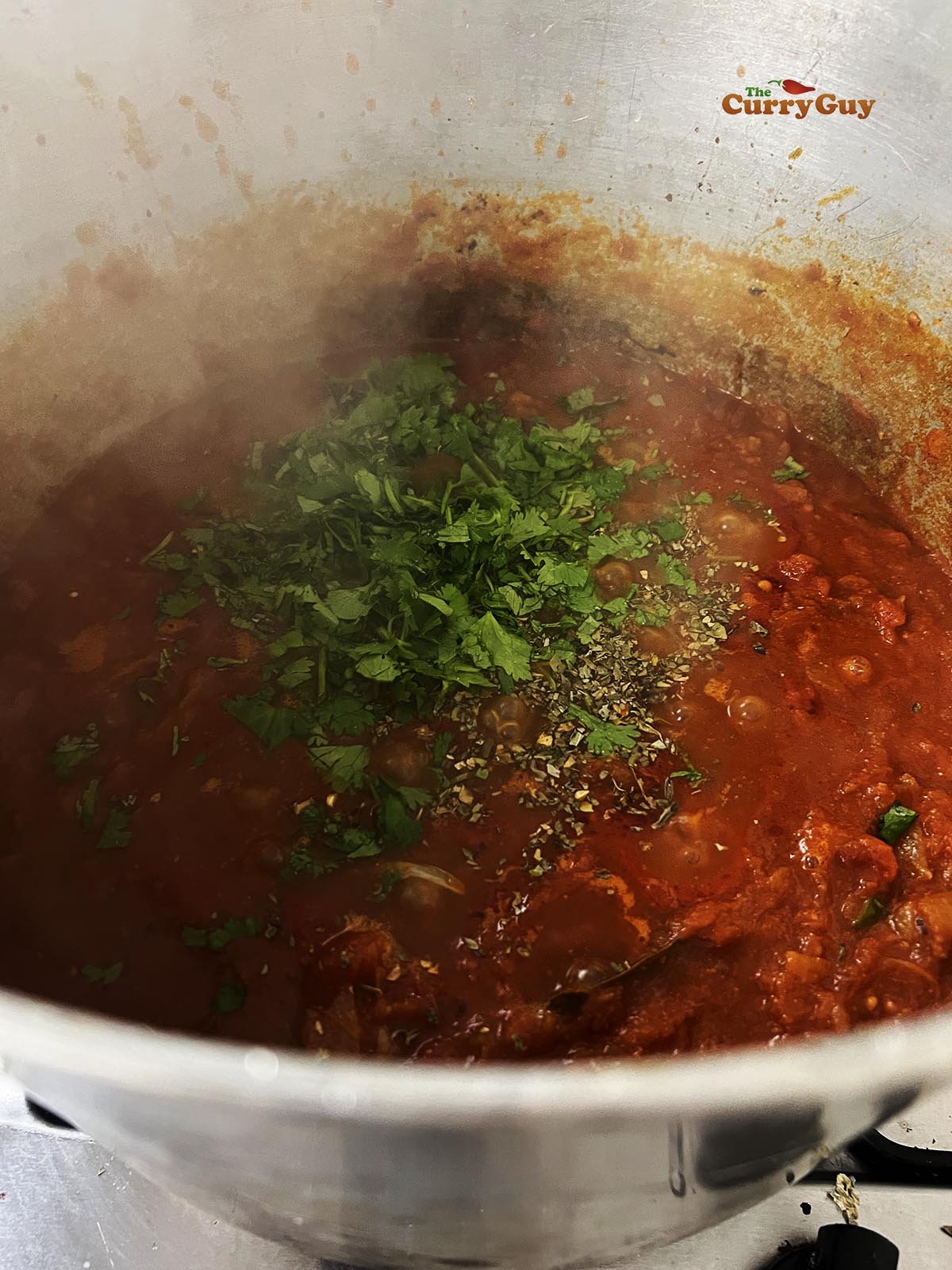 Adding the chopped coriander and kassori methi to the pot.