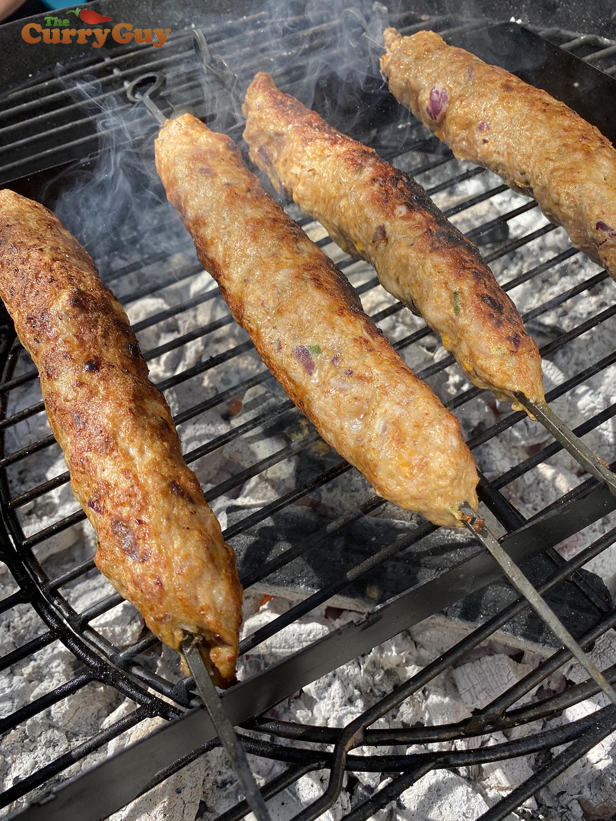 meat skewers cooking over the coals