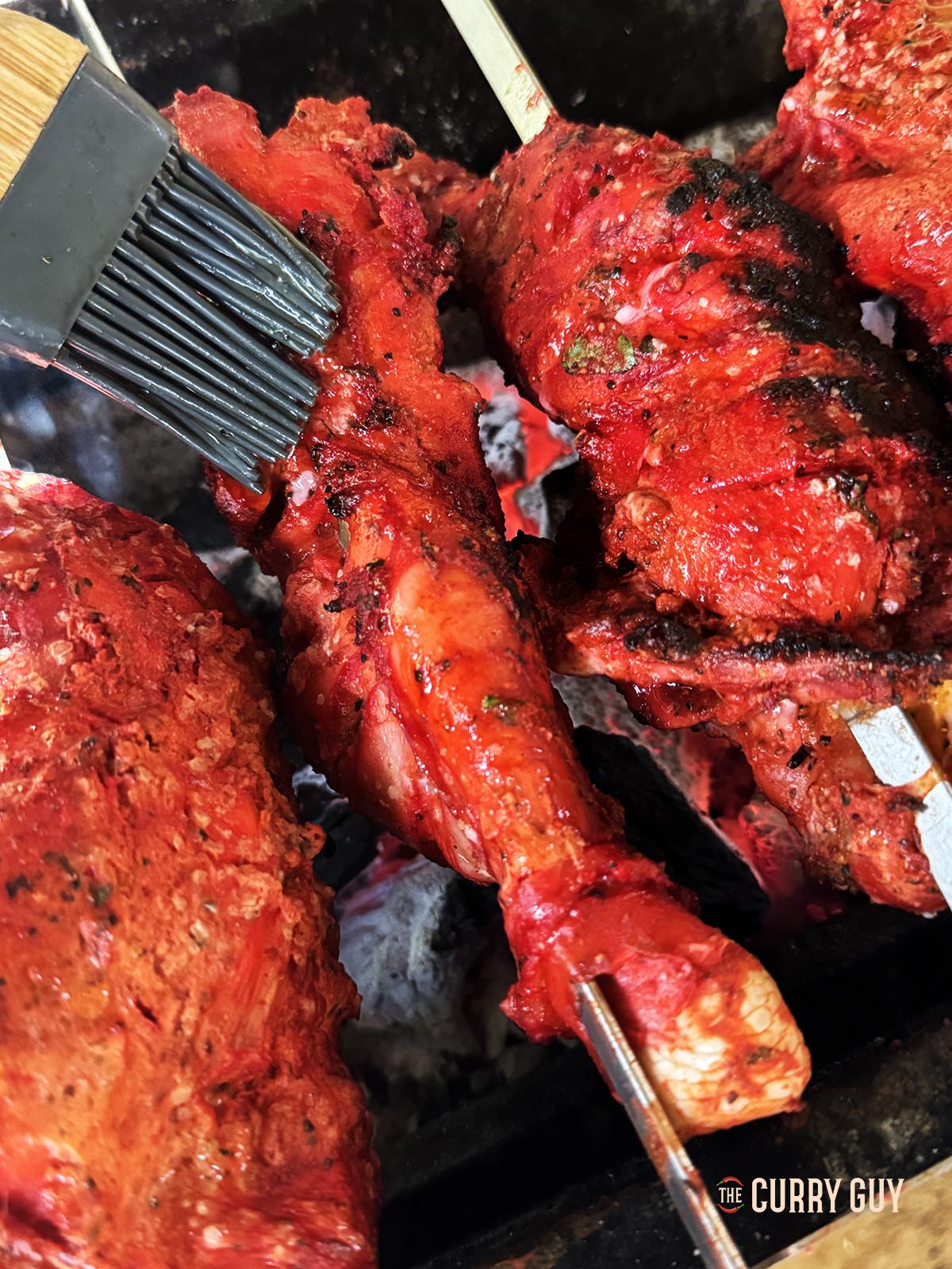 Basting the chicken with melted ghee.