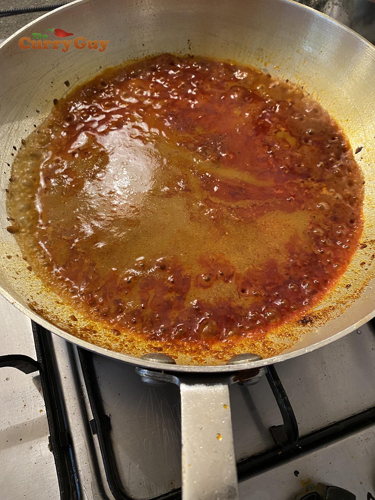 Stirring in tomato puree and base sauce