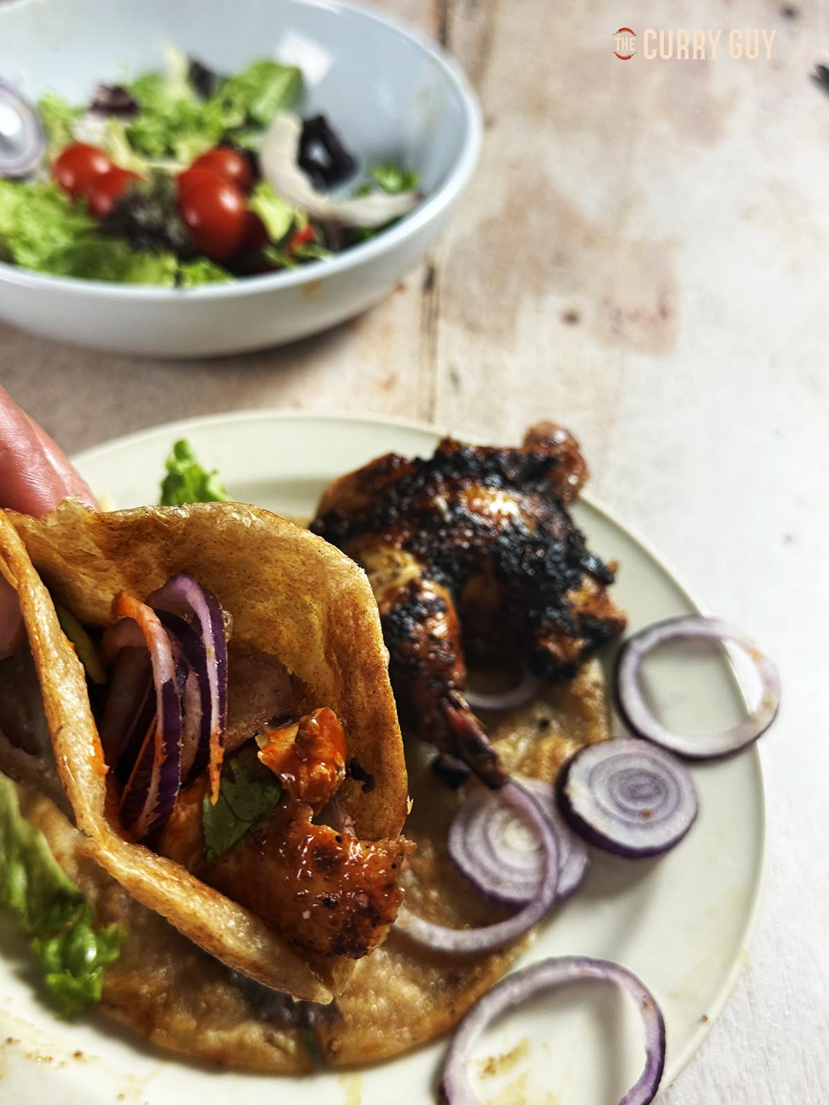 Roast pheasant from the tandoor oven in a wrap with salad vegetables and sauces.