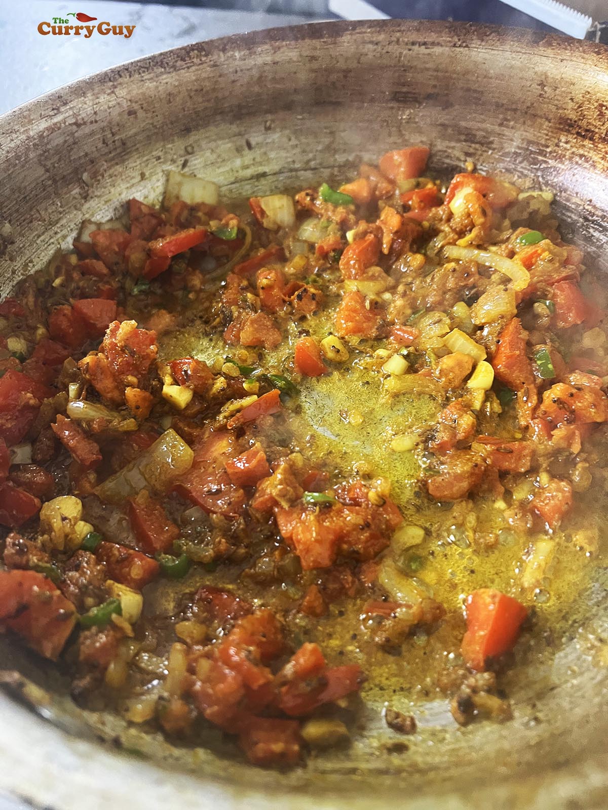 Continuing to fry the tarka to soften and mix the flavours.