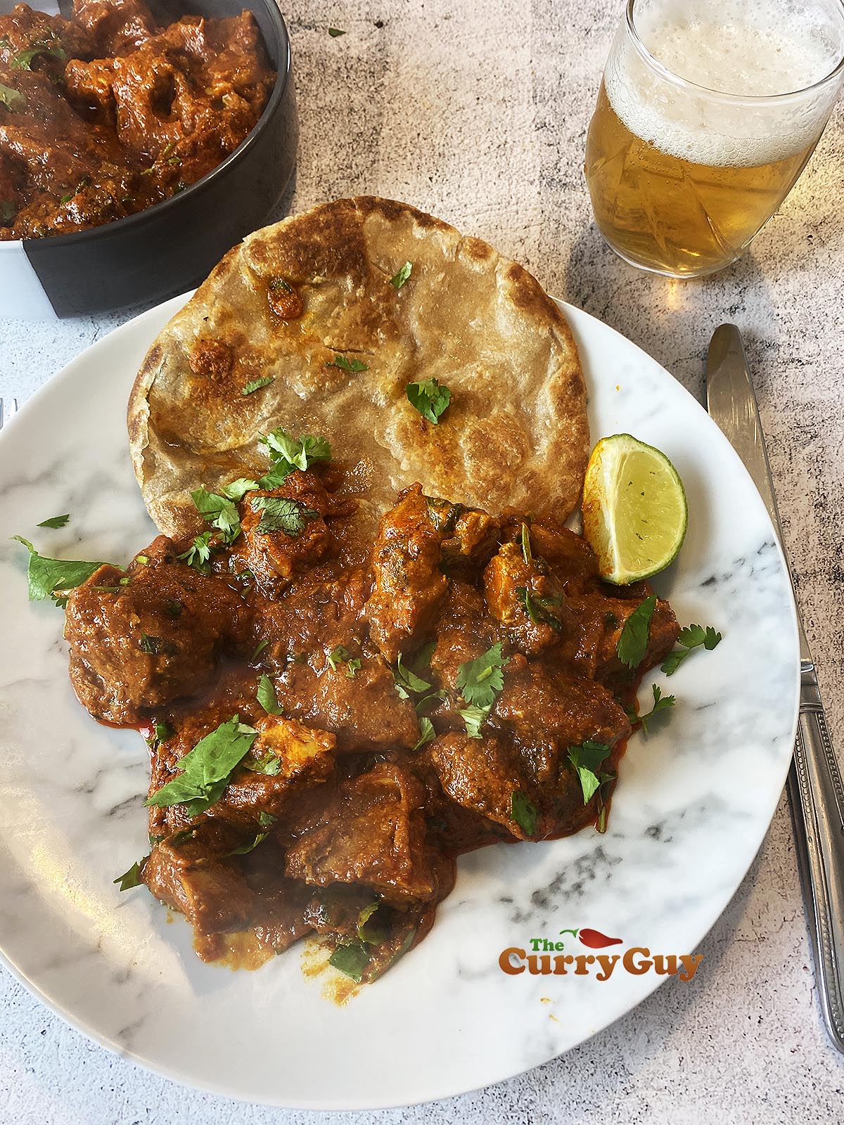 Chicken Madras curry on a serving plate with chapati.
