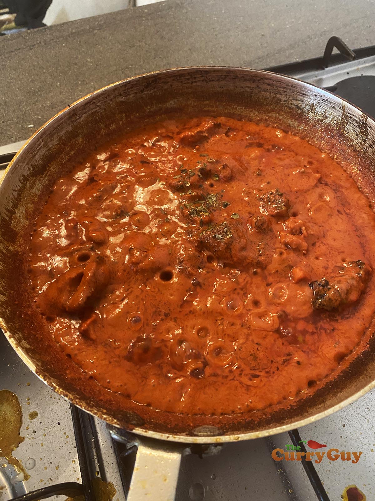Adding cream to the pan and then adding the kasoori methi