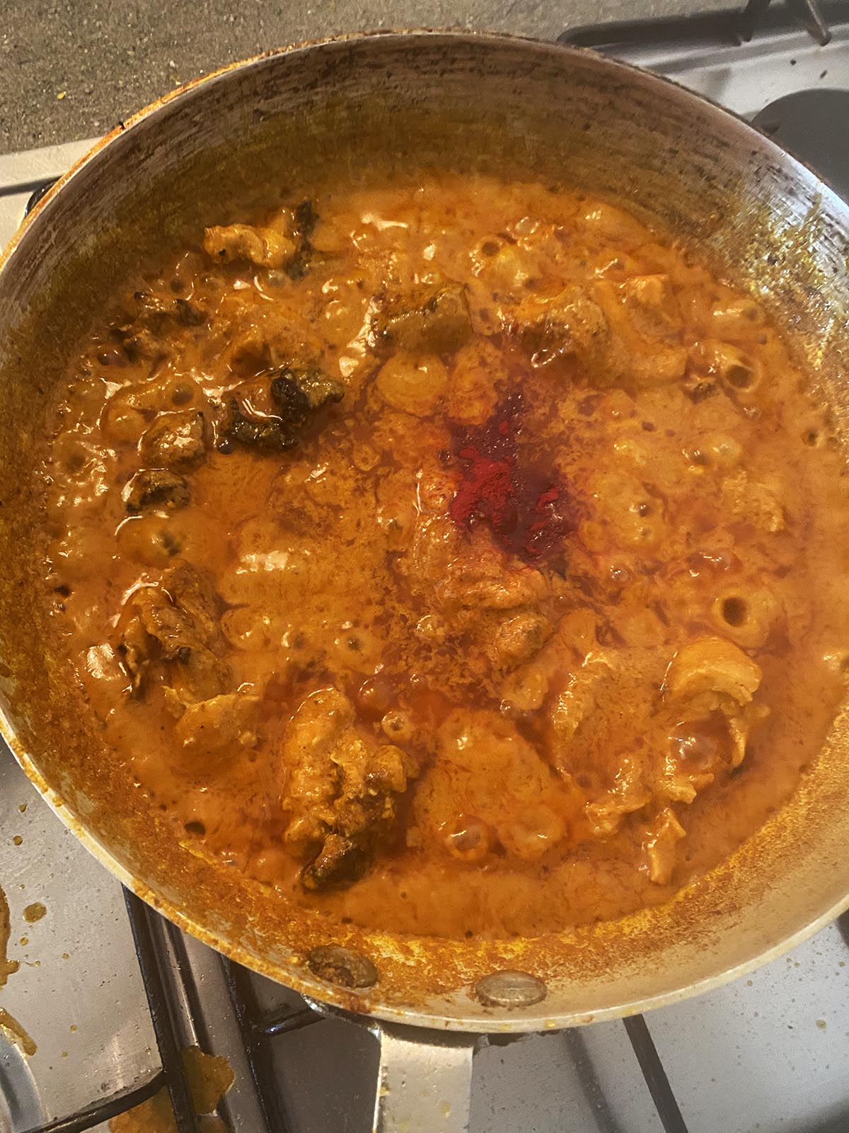 Adding food colouring to the sauce in the pan