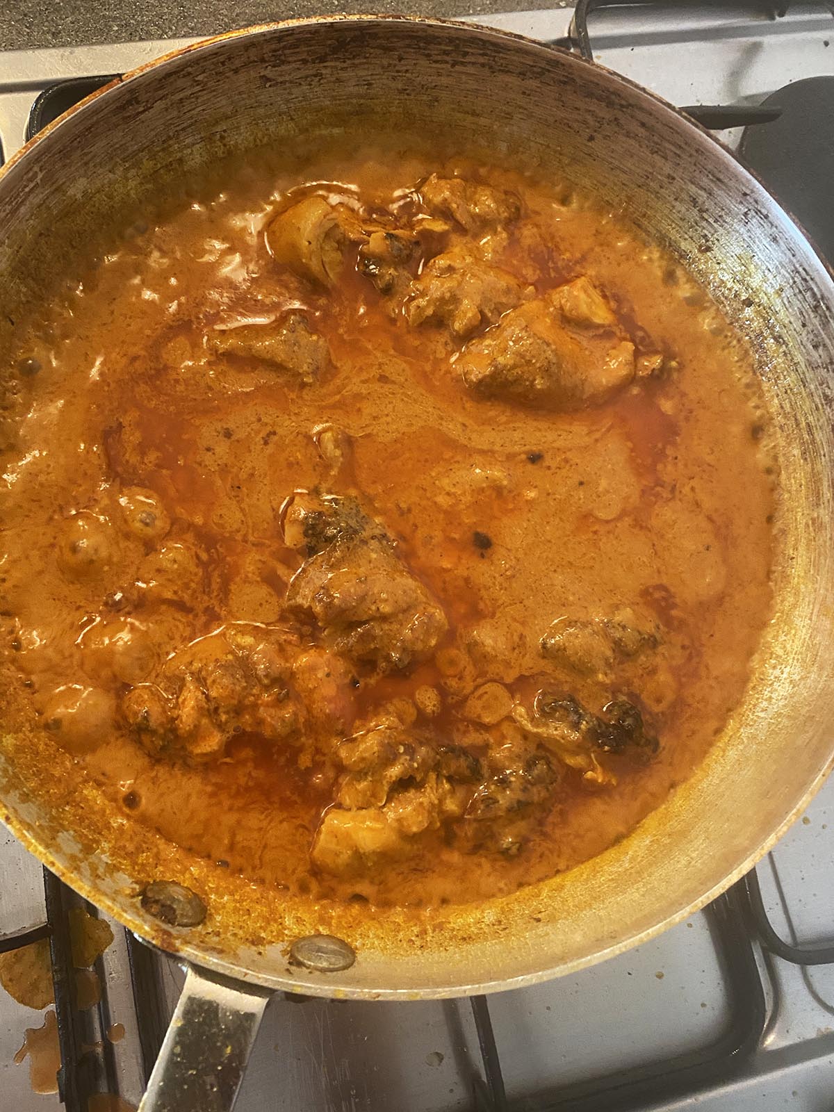 Adding tandoori chicken to the sauce in the pan