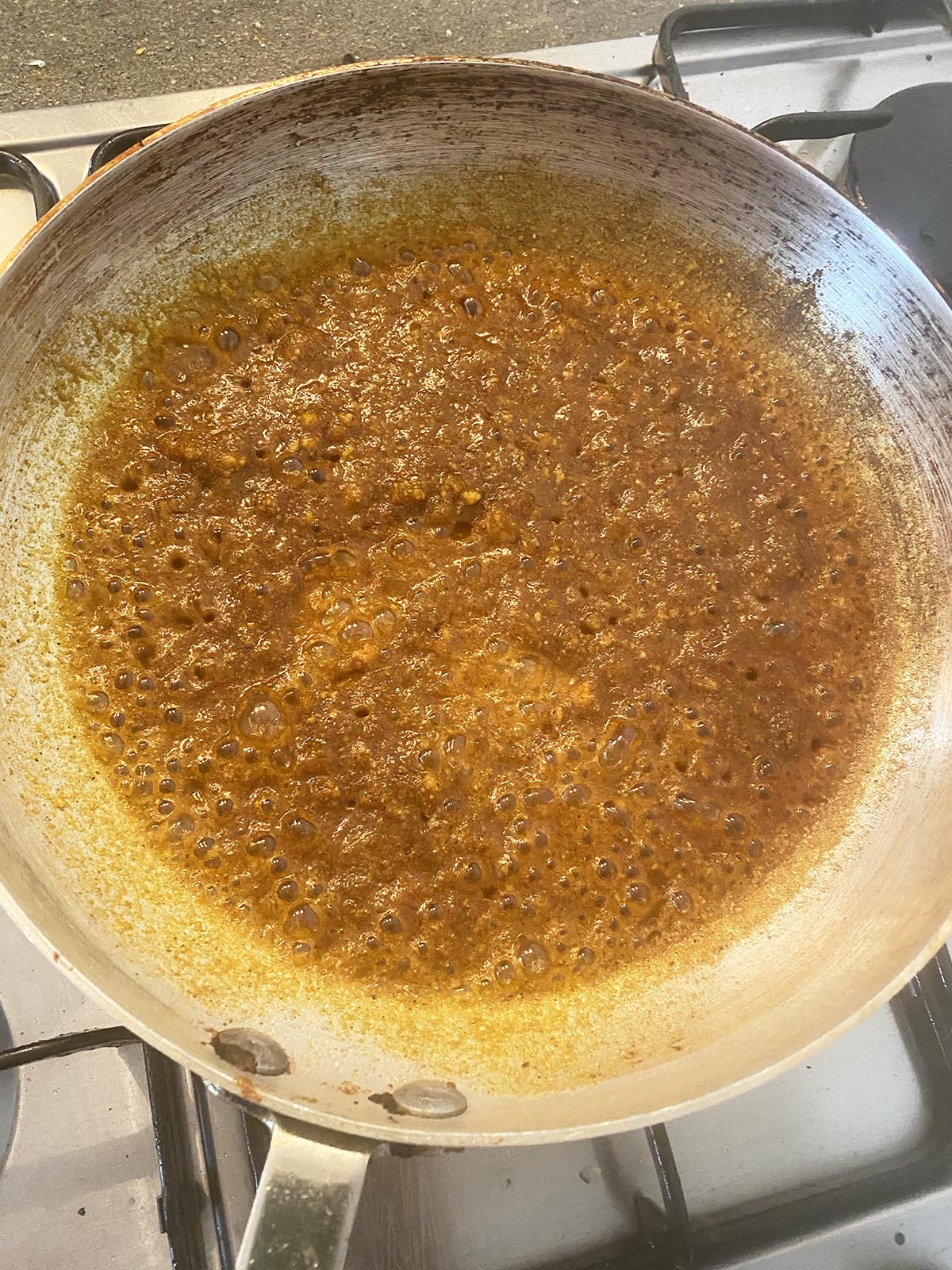 adding ground spices to the pan and stirring them into the oil, garlic and ginger.