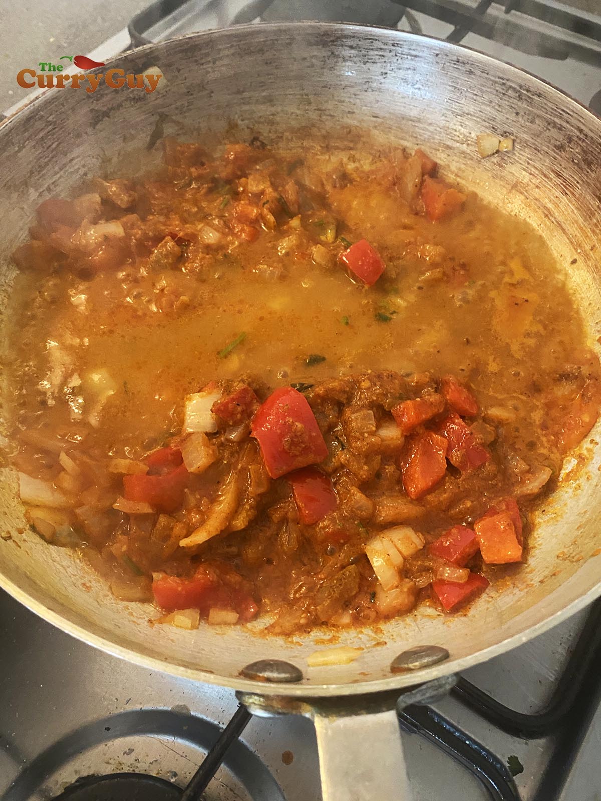 Adding base curry sauce to the pan