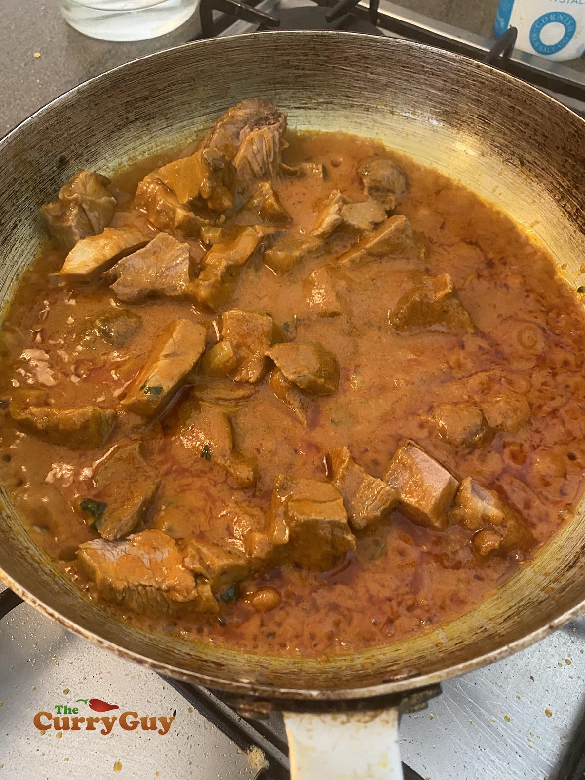 Stirring the lamb into the sauce