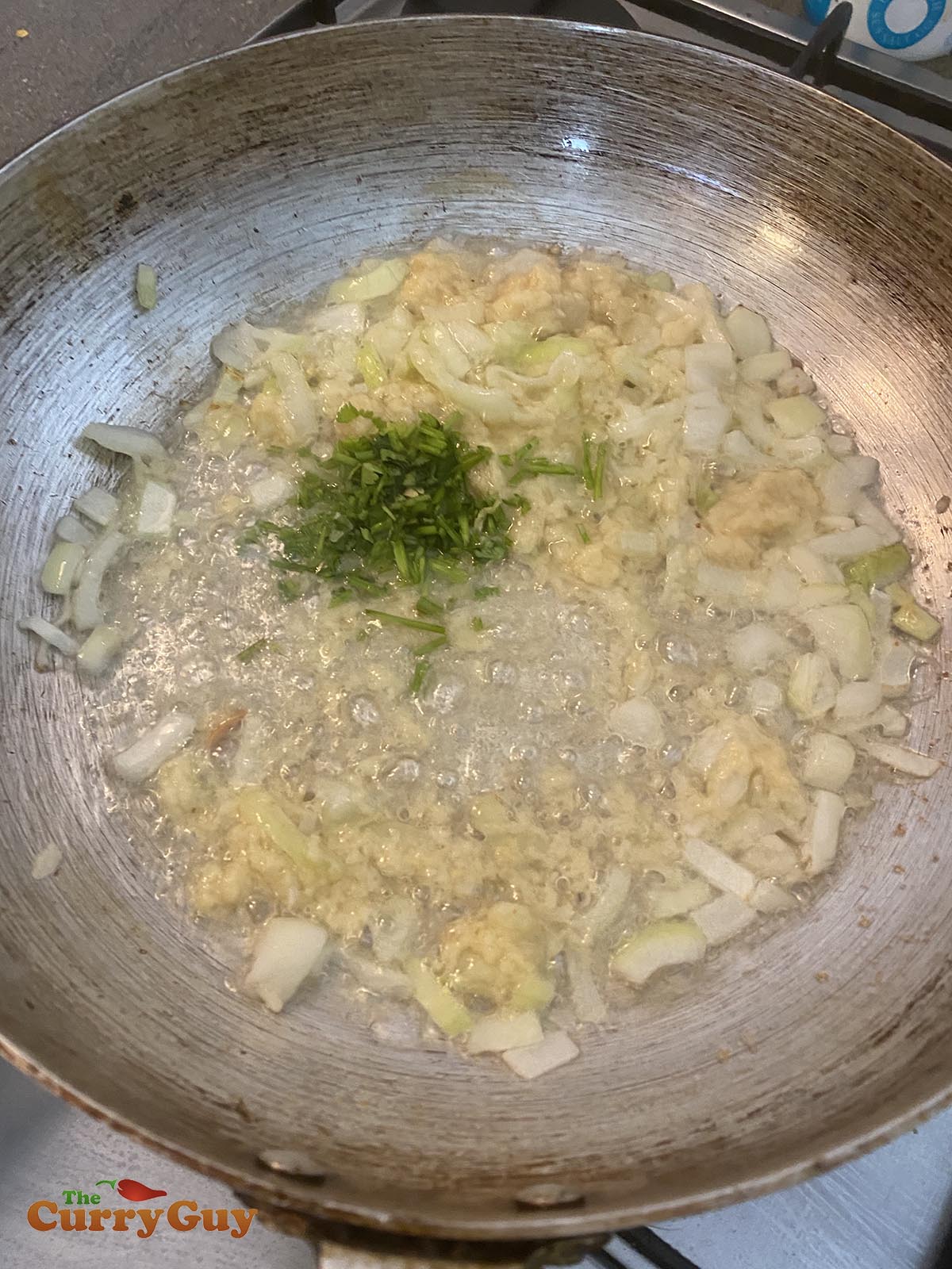 stirring coriander (cilantro) stems into the pan