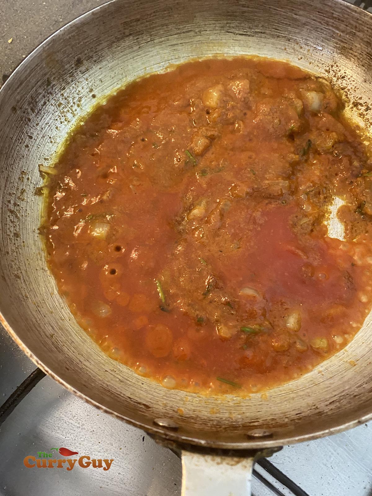 Adding tomato puree to the pan
