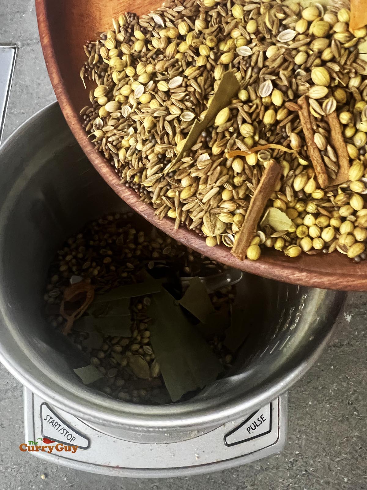 Adding the roasted spices to a spice grinder