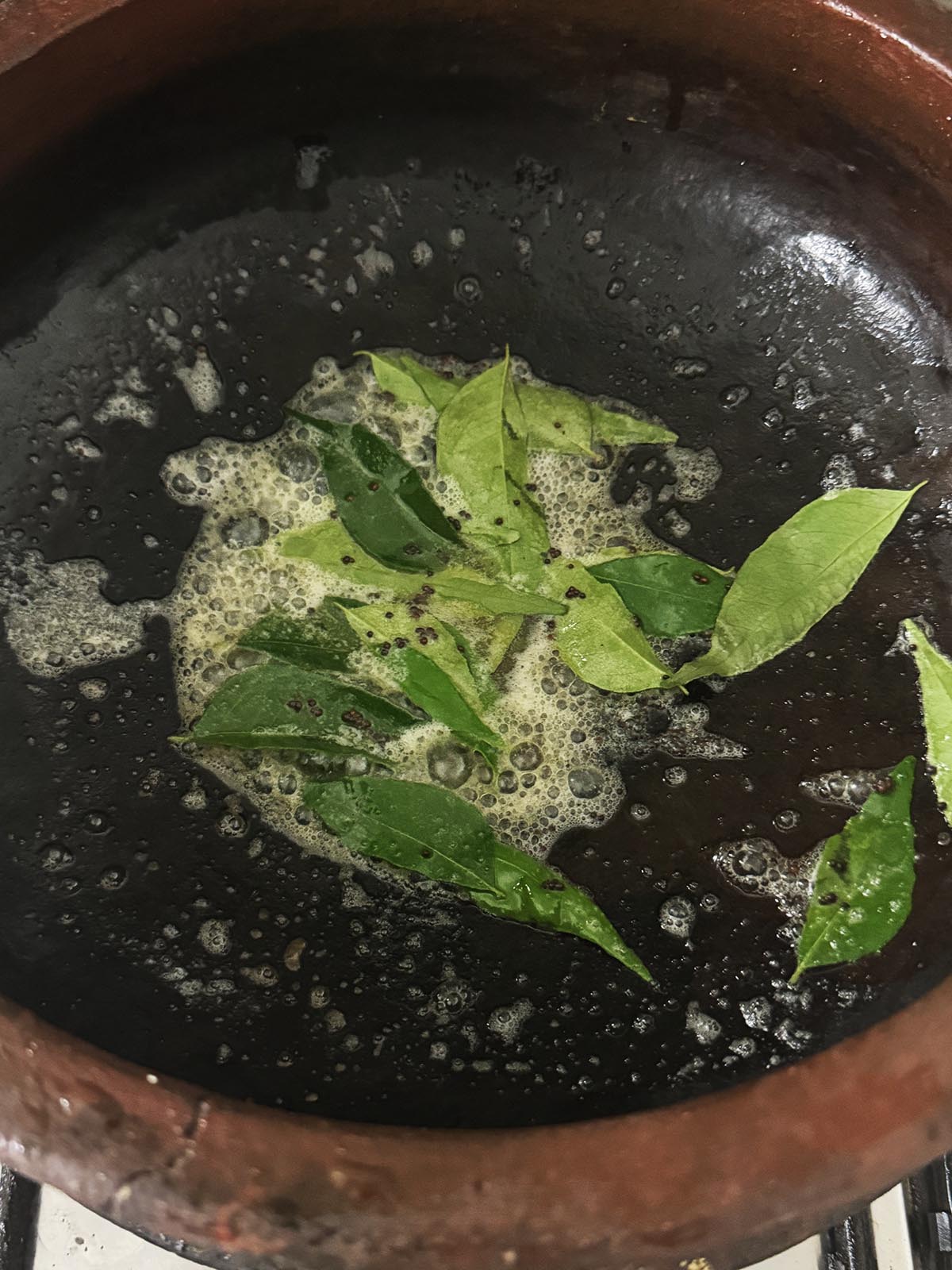 Infusing the mustard seeds and curry leaves into the melted butter.