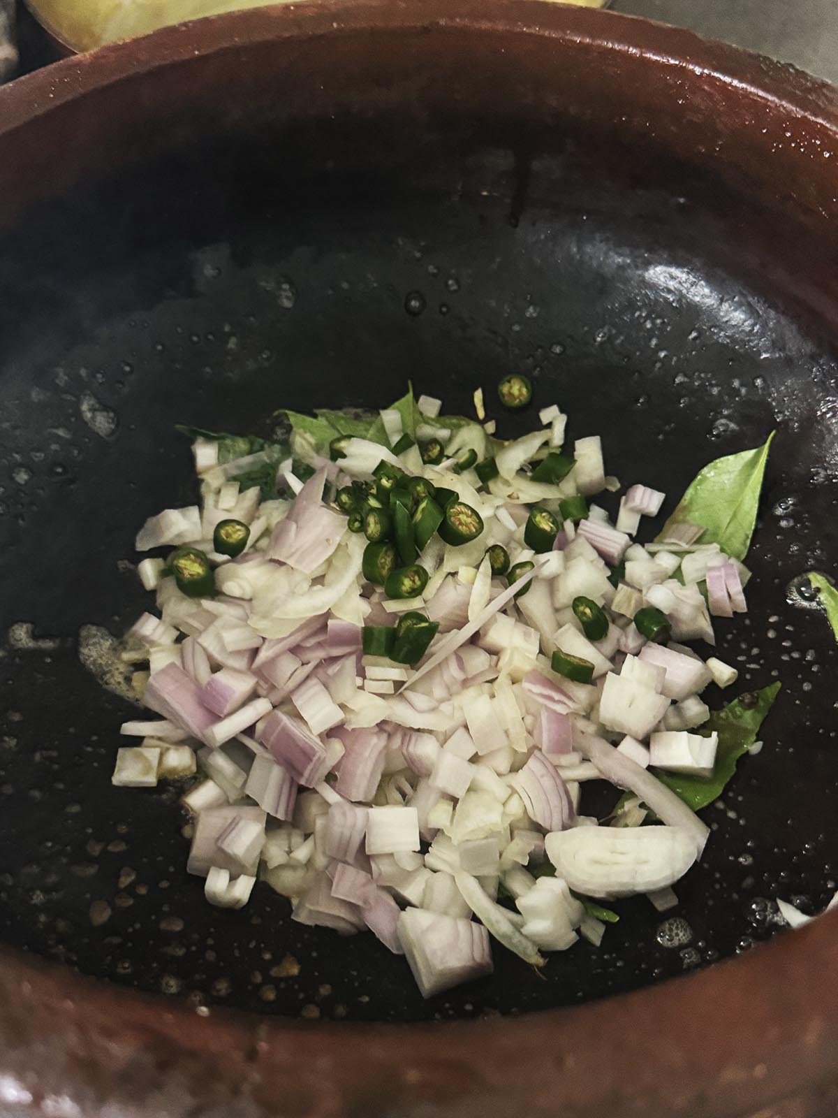 Adding the shallots to the pot. 