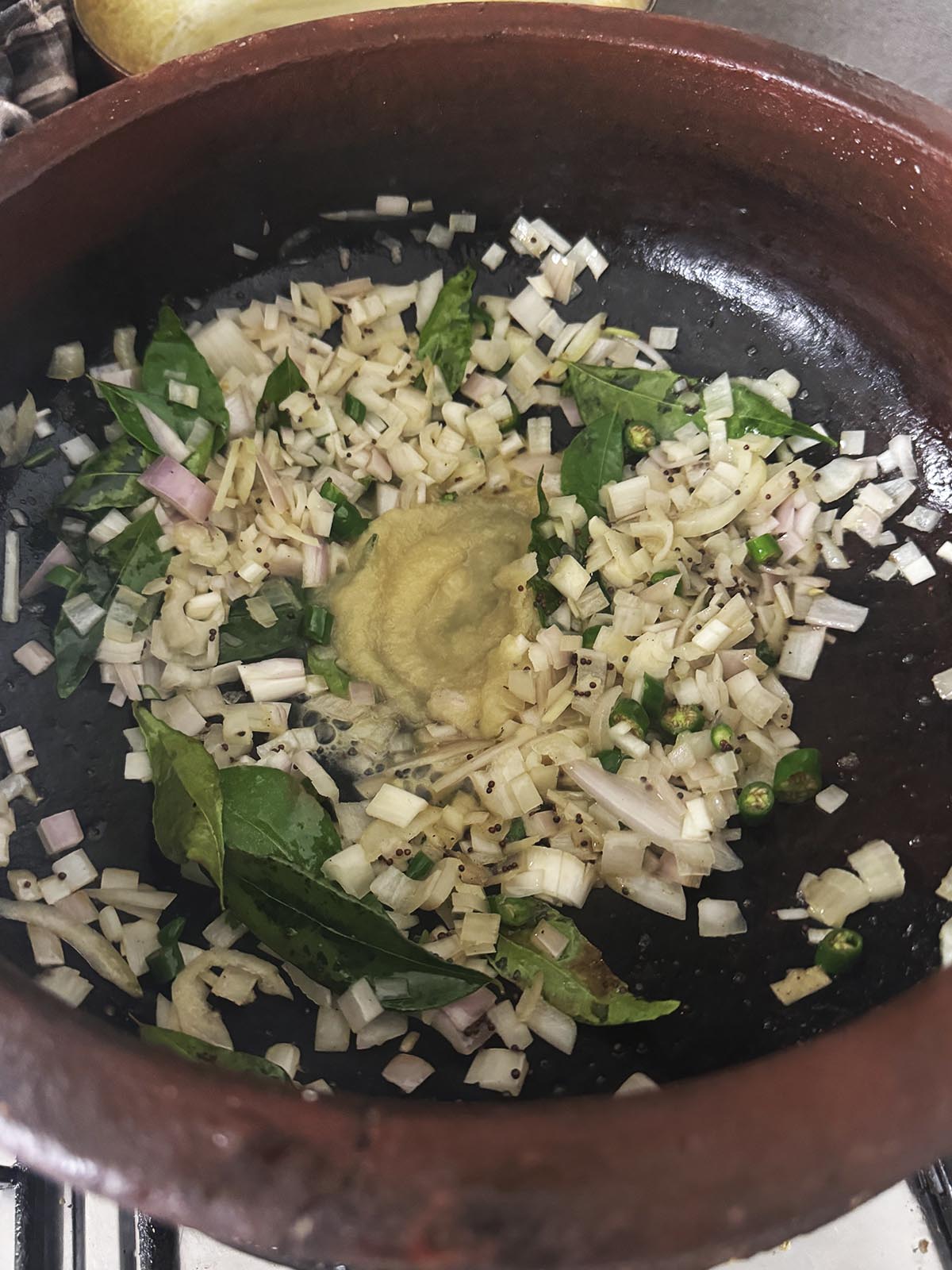 Adding garlic and ginger paste to the pot. 