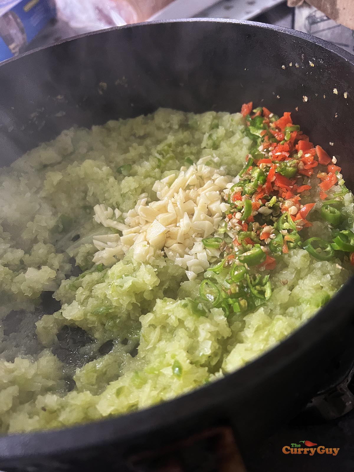 Frying the onion, bell pepper, chillies and garlic.