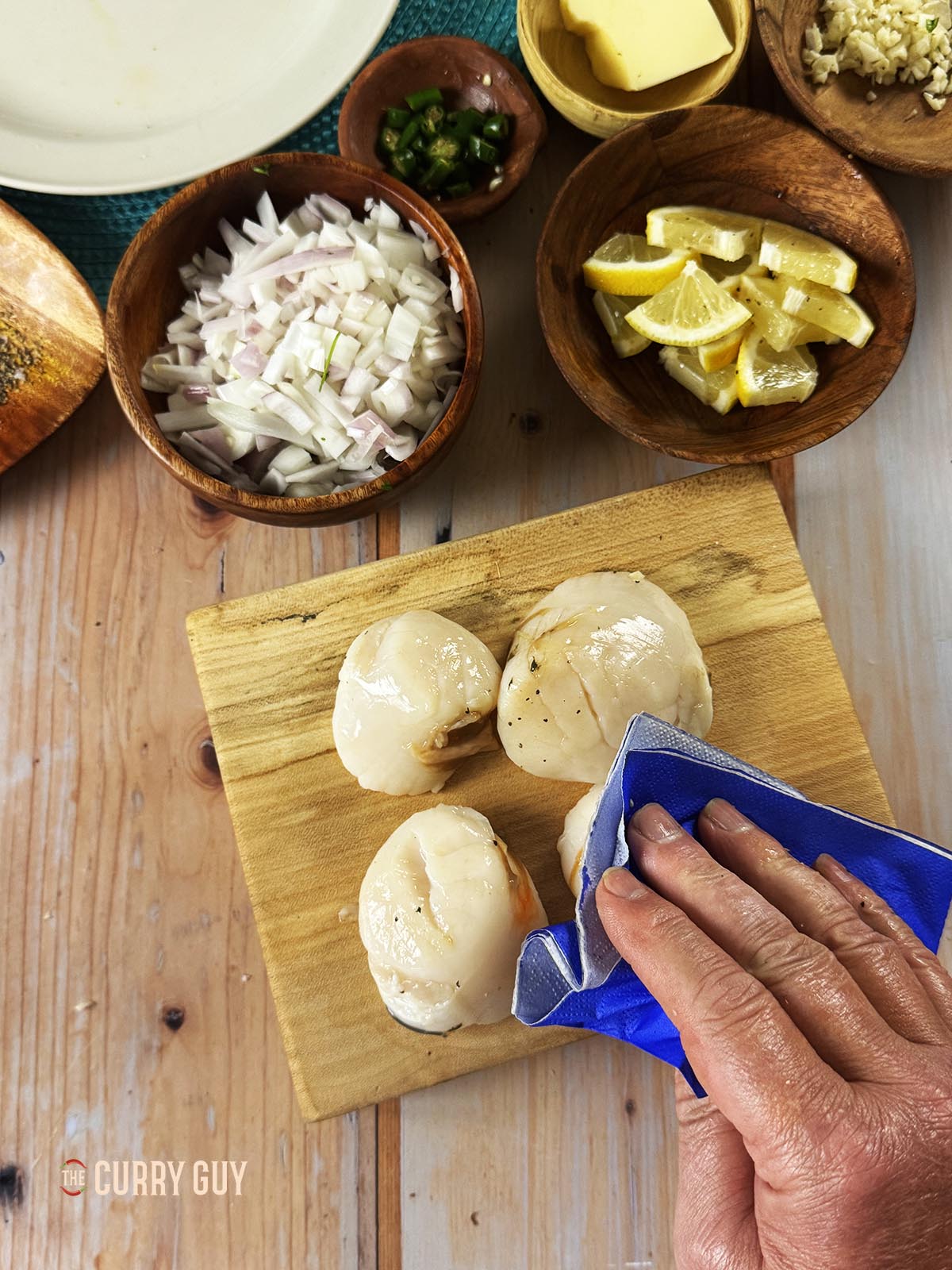 Drying the scallops with a paper napkin.
