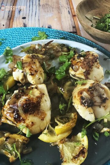 Serving the pan seared scallops on a plate with the sauce.