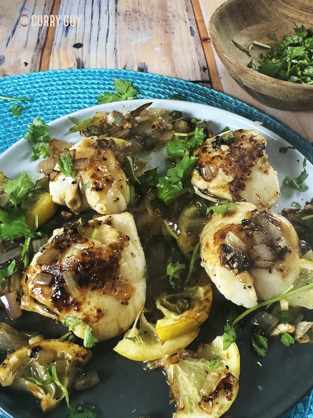 Serving the pan seared scallops on a plate with the sauce. 