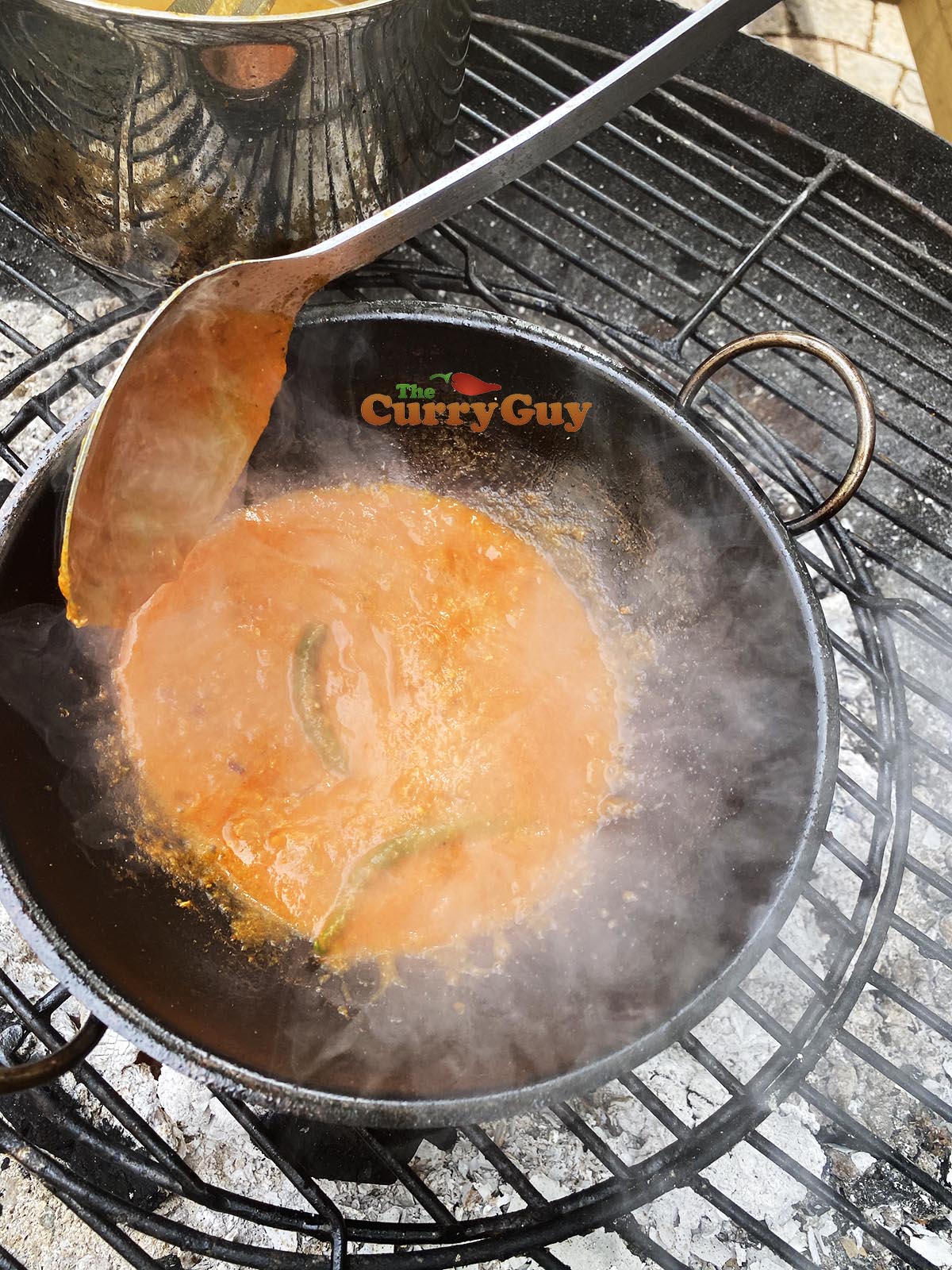 Adding base sauce to prawn balti