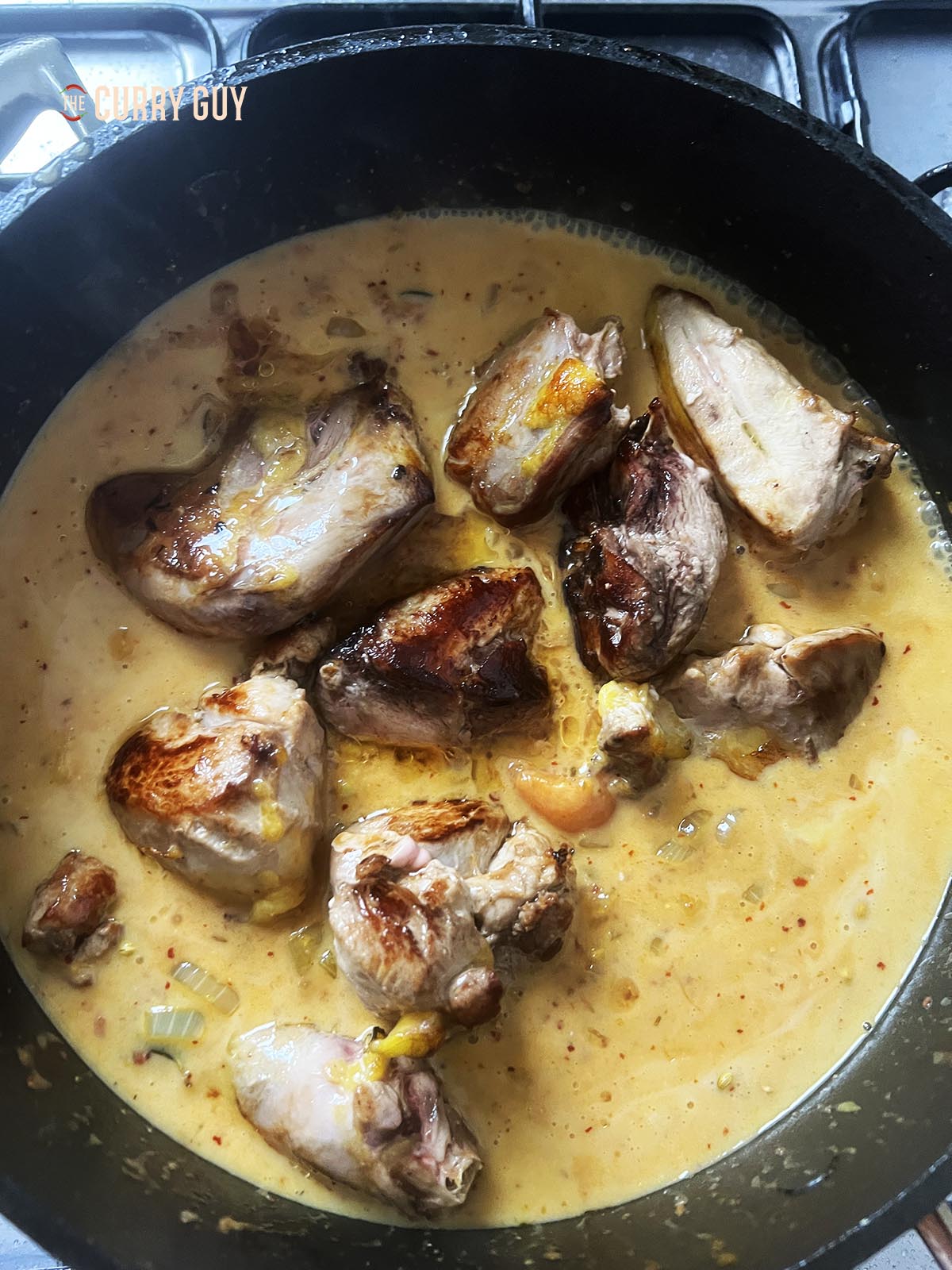 Returning the browned pheasant to the pan with stock for the sauce.