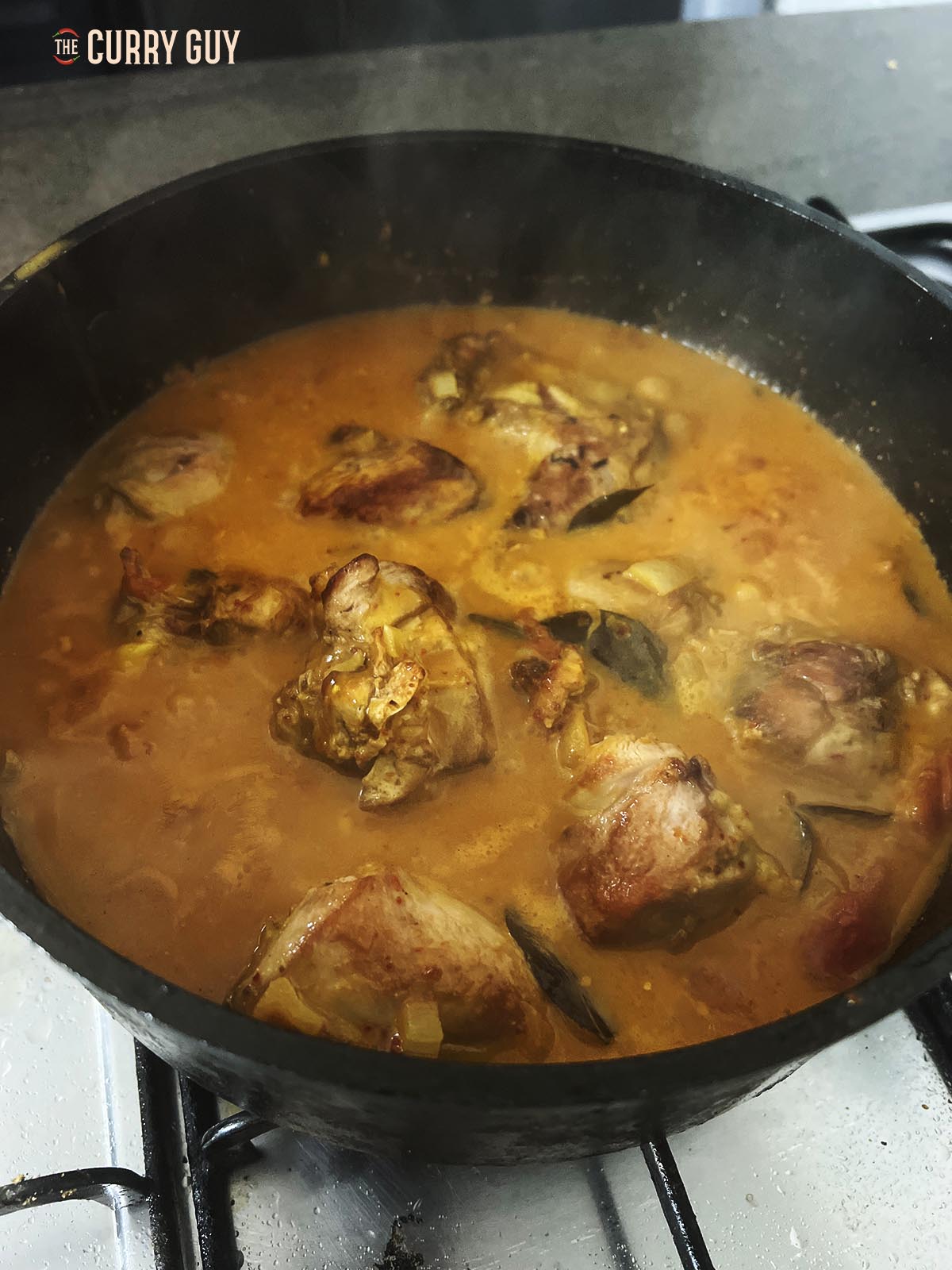 Simmering the sauce in the pan with the lid off. 