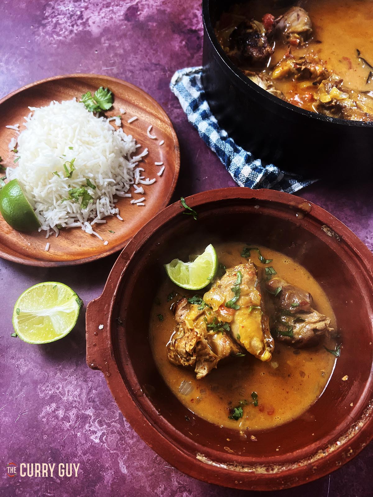 Pheasant curry served at the table with Basmati rice and lime wedges.