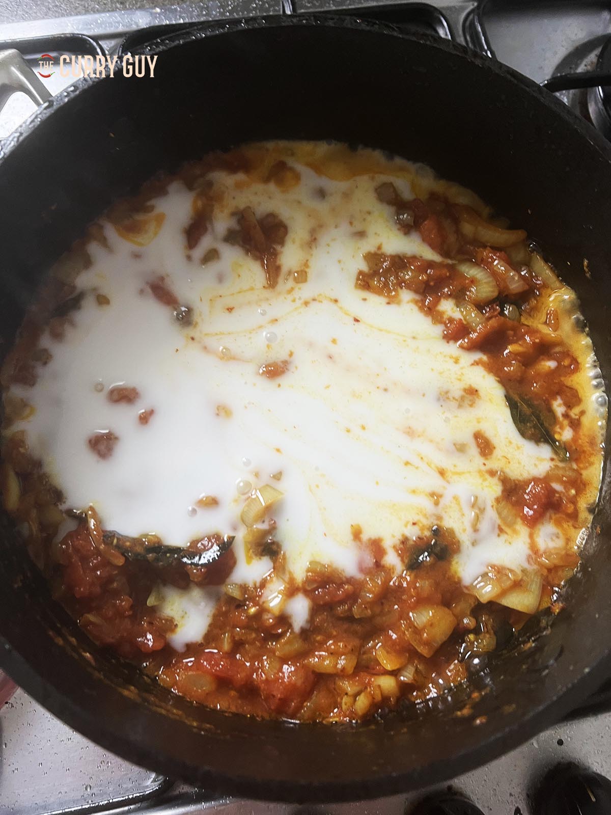 Pouring the coconut milk into the pan.