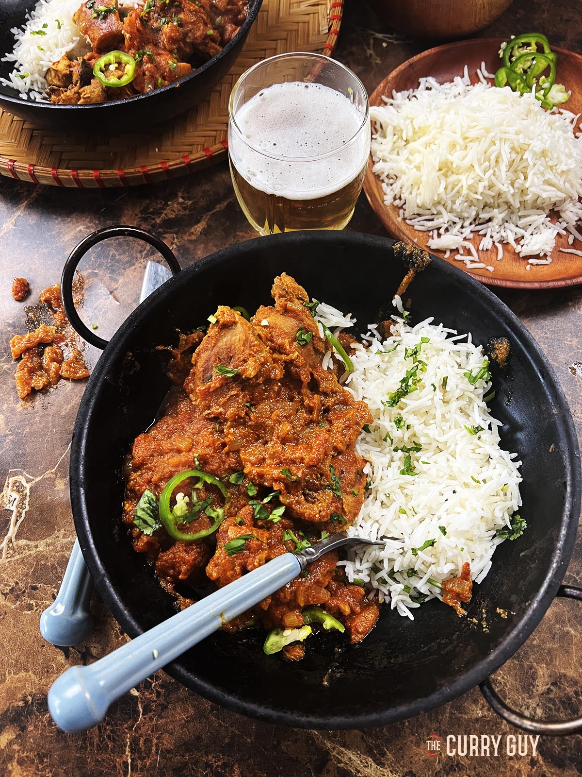 Spicy pheasant curry with rice served at the table.