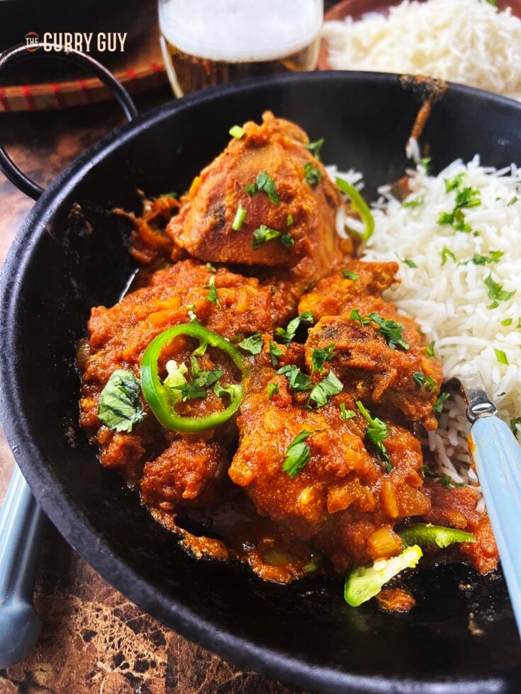 Spicy pheasant curry served with rice at the table.