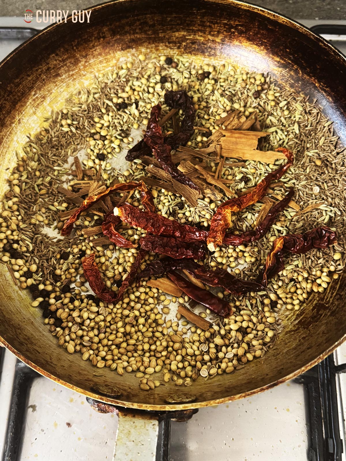 Roasting the whole spices in a pan.