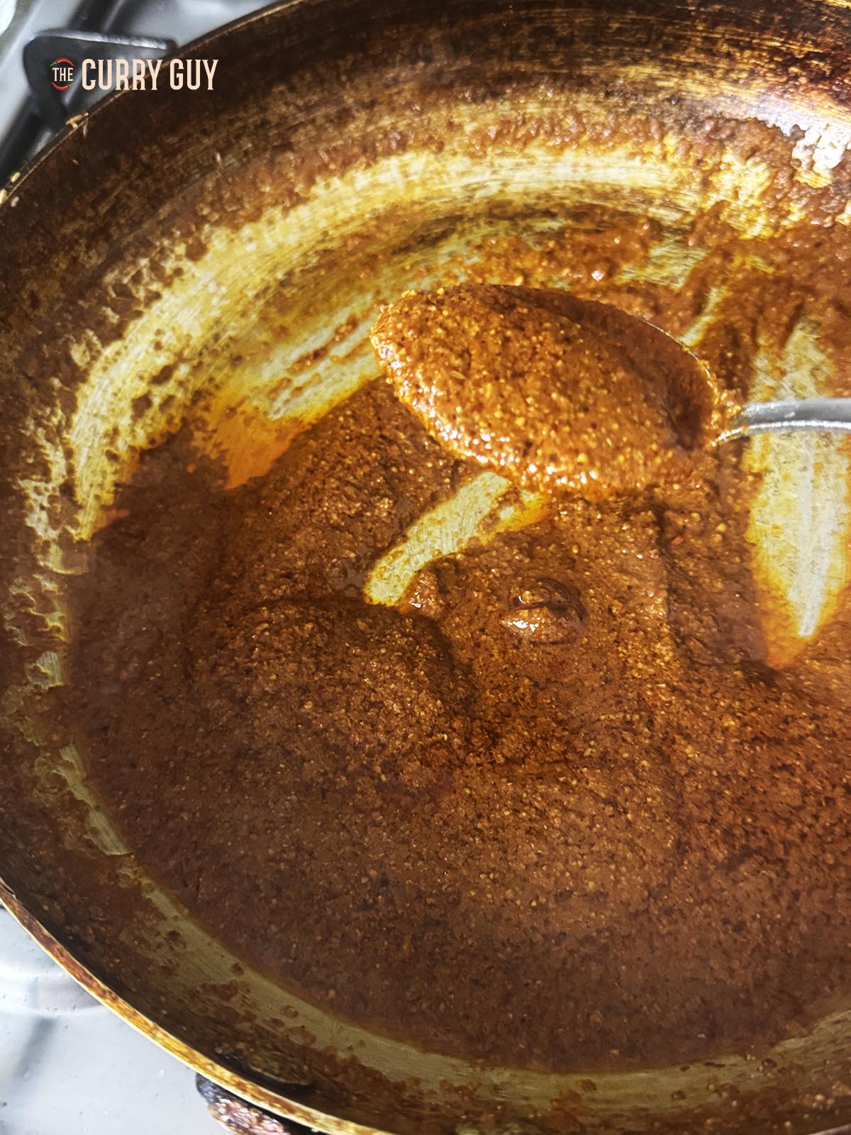 A spoonful of the curry paste taken from the pan.
