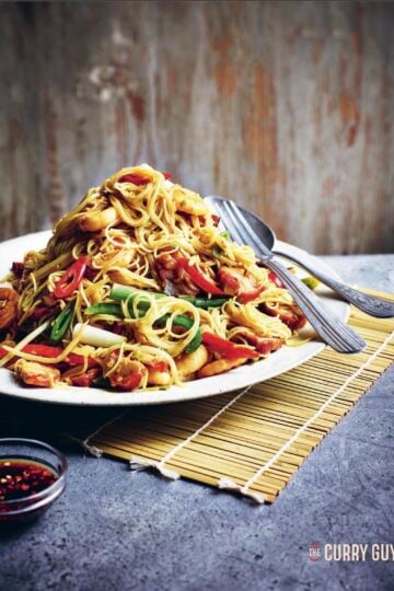 Singapore Noodles on a serving plate at the table.