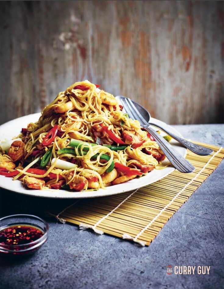 Singapore Noodles on a serving plate at the table.