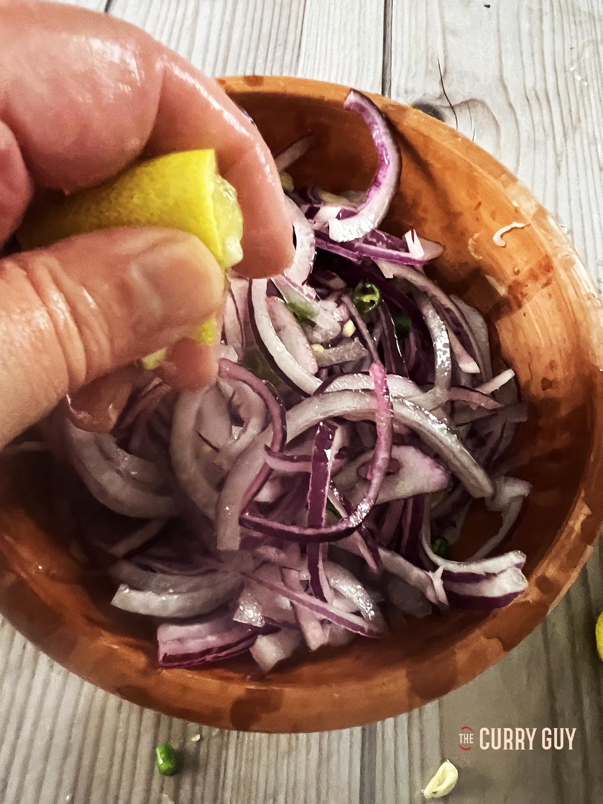 Squeezing lemon juice over the onions and adding salt and sugar.