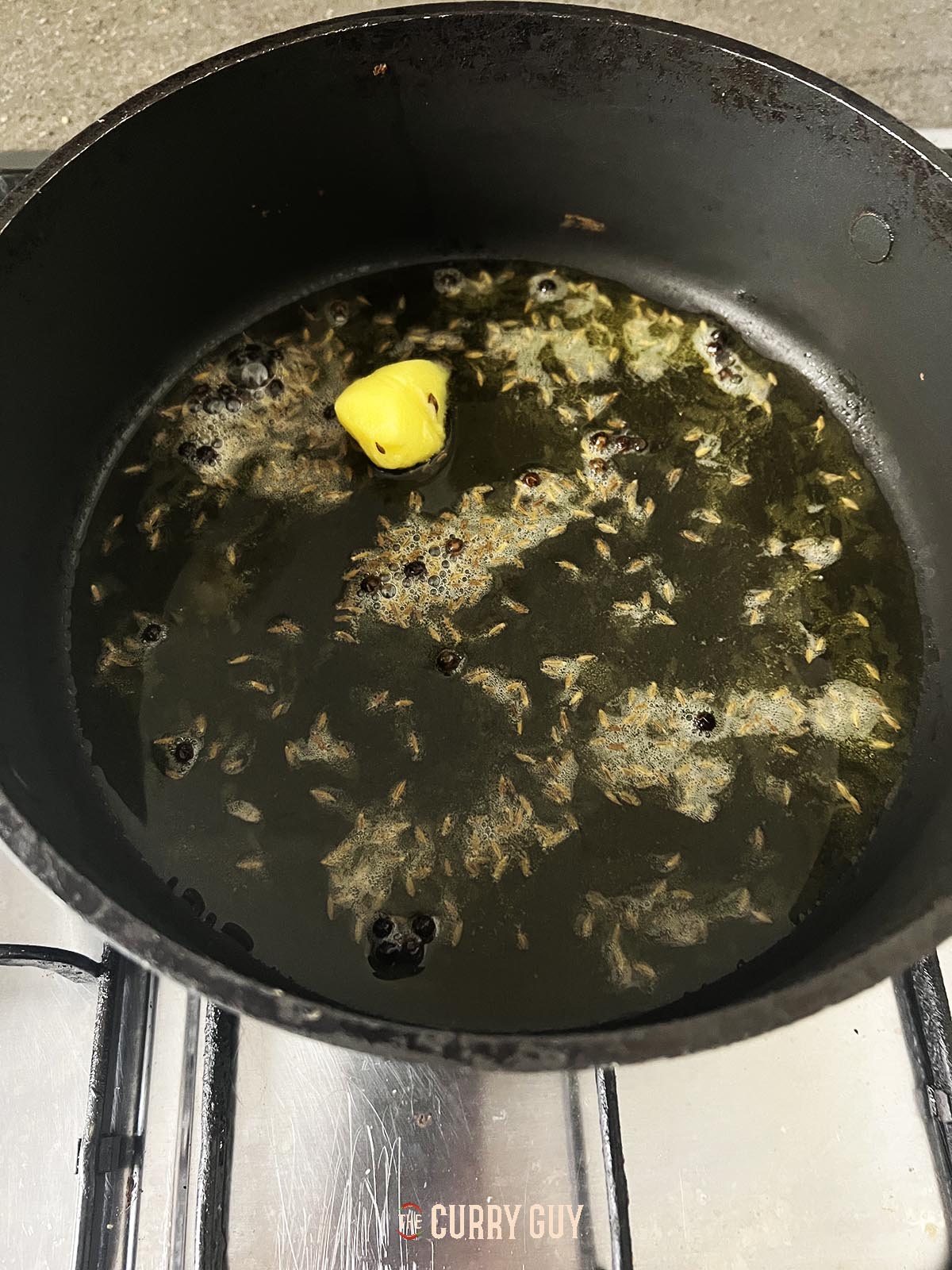 Infusing the whole spices in the oil in the pan.