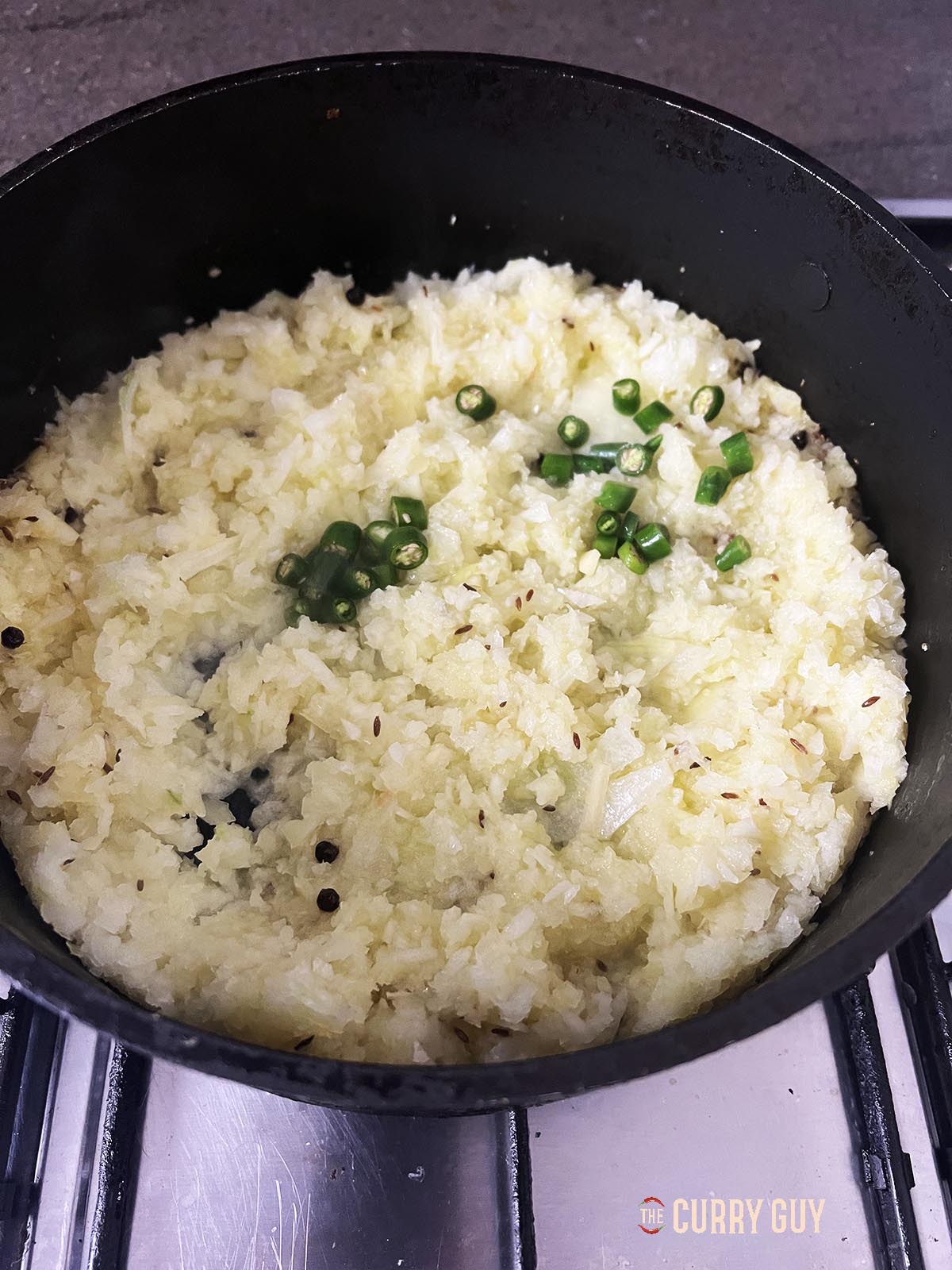 Adding chopped onions and chillies to the pan.