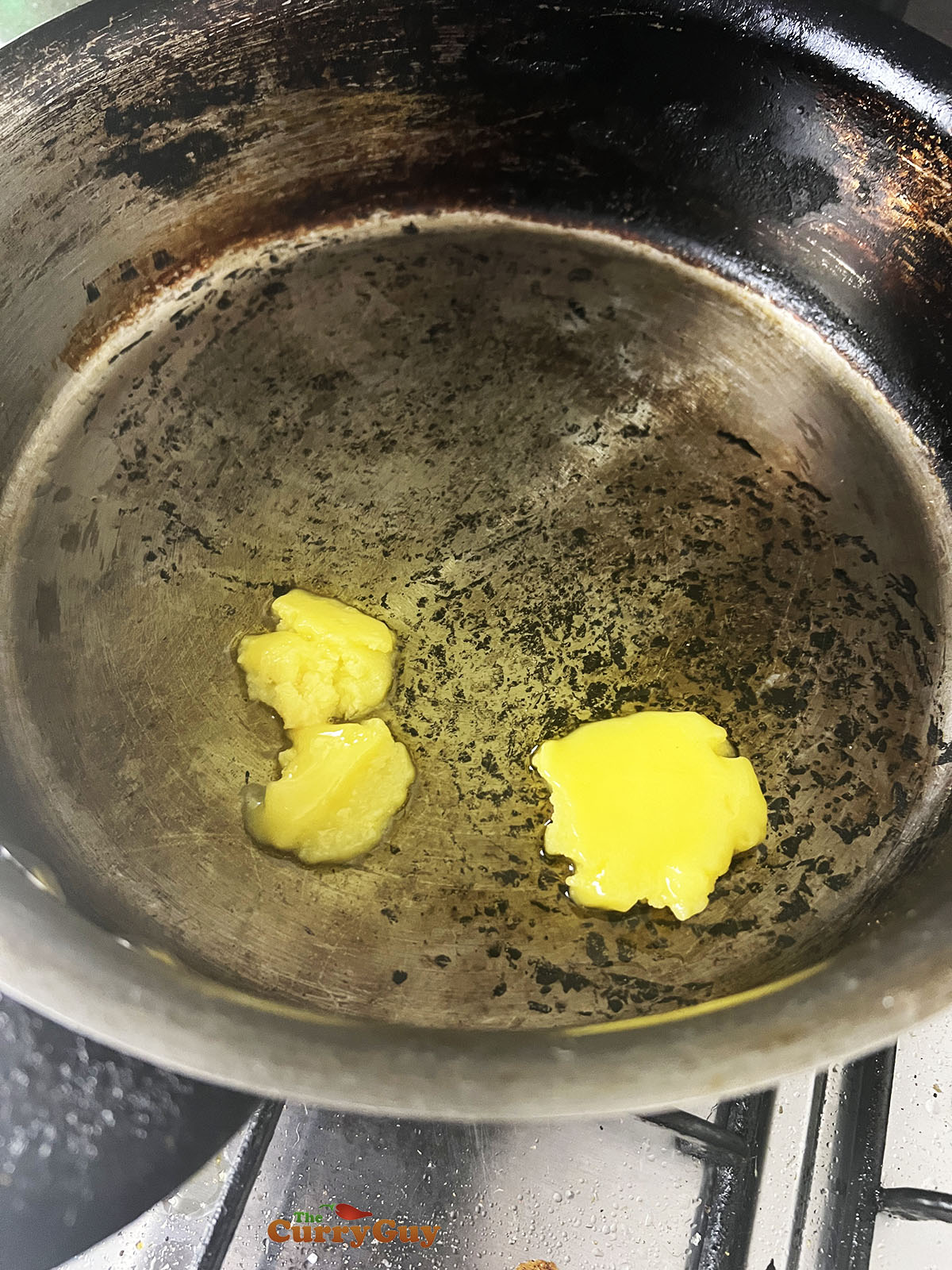 Melting ghee in a large frying pan.