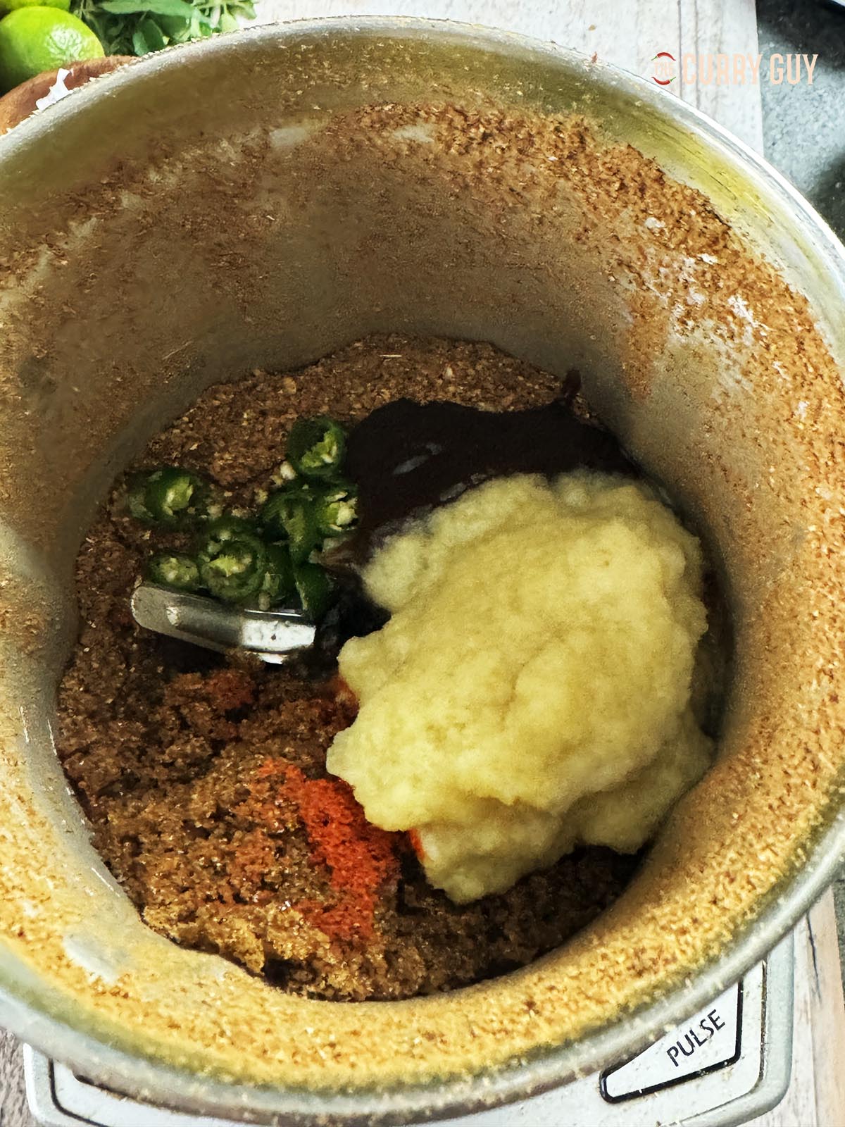 Adding the garlic and ginger paste, chillies and one tbsp vinegar to the ground spices.