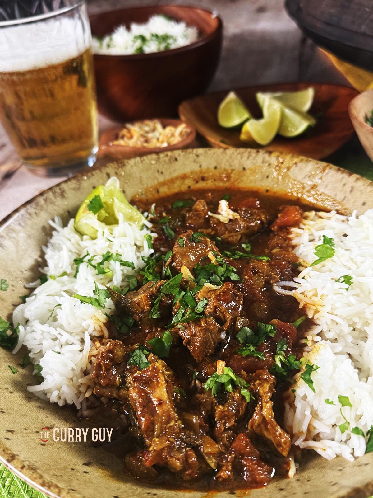Pork vindaloo served with rice and garnished with fried garlic and chopped coriander.